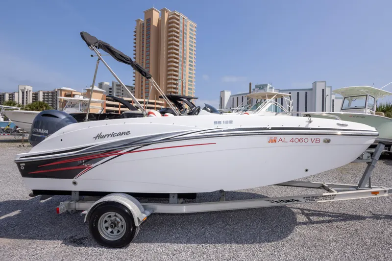 Slide: The Image of 2018 Hurricane SunDeck Sport 192 OB boat on trailer, cityscape background. - 5