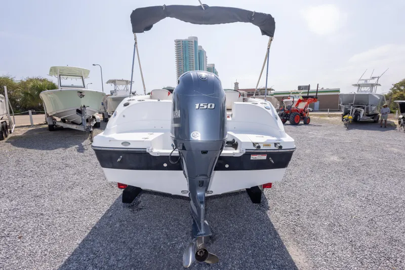 Slide: The Image of 2018 Hurricane SunDeck Sport 192 OB boat with Yamaha 150 engine, parked on gravel. - 9
