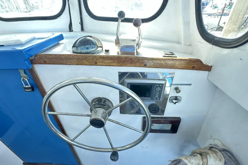 Slide: The Image of Interior of a 1990 Seeway 31 boat cockpit with steering wheel and navigation controls. - 11