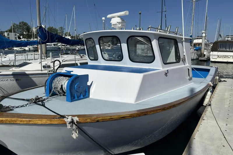 Slide: The Image of 1990 Seeway 31 boat docked at marina, featuring a blue and white exterior. - 2