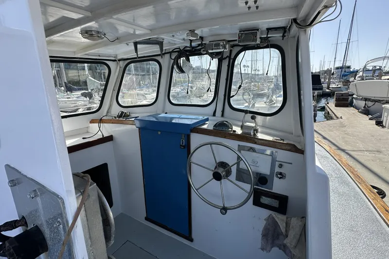 Slide: The Image of Interior of a 1990 Seeway 31 boat with steering wheel and marina view. - 4