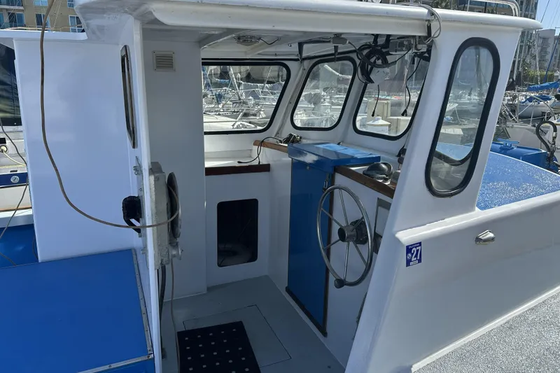 Slide: The Image of 1990 Seeway 31 boat cockpit with steering wheel and marina view. - 5