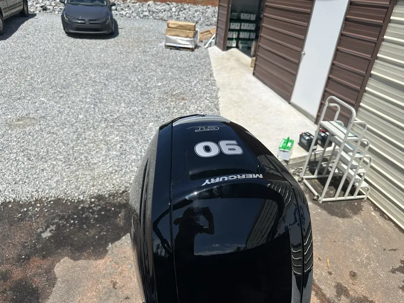 Slide: The Image of Mercury 90 HP outboard motor on gravel surface near storage building. - 11
