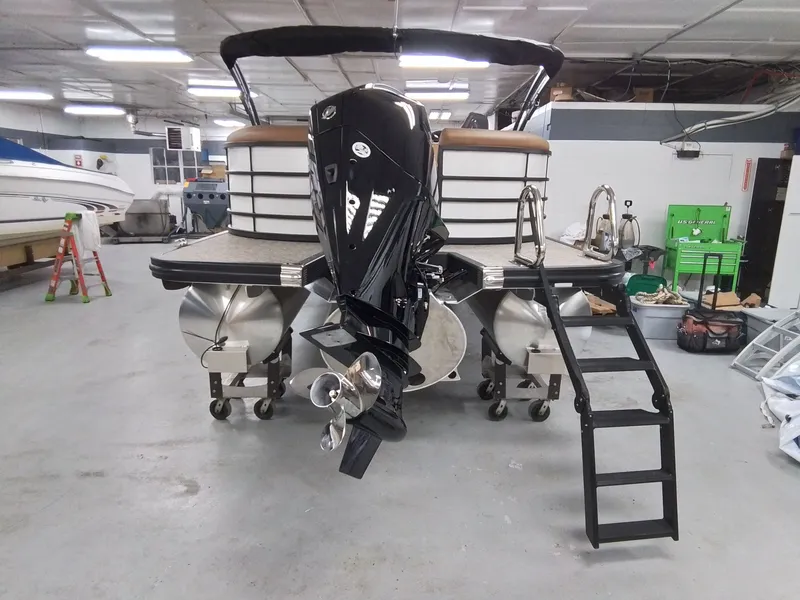 Slide: The Image of Bennington 25RSRSF 2026 pontoon boat in storage with outboard motor. - 5