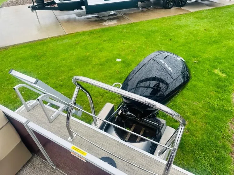 Slide: The Image of 2024 Godfrey Pontoons 2286 SB with outboard motor on green lawn. - 16