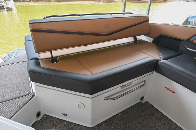 Slide: The Image of 2022 Cobalt R6 Surf boat interior with tan and black seating, near water. - 16