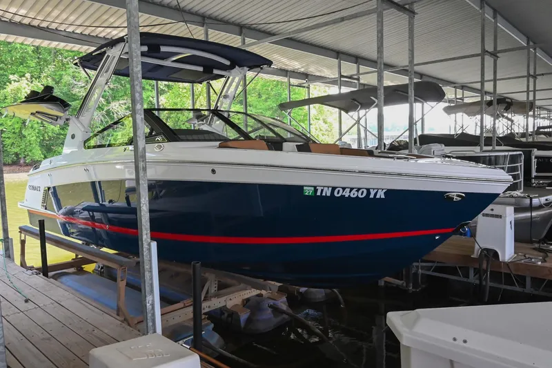 Slide: The Image of 2022 Cobalt R6 Surf boat docked in a covered marina, featuring sleek design and modern amenities. - 2