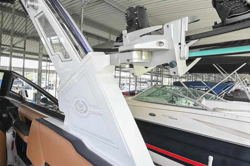 Slide: The Image of 2022 Cobalt R6 Surf boat interior with wakeboard rack in marina setting. - 21