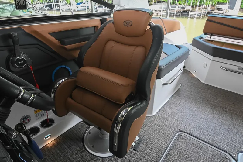 Slide: The Image of Captain's chair in 2022 Cobalt R6 Surf boat interior, featuring luxurious brown upholstery. - 32