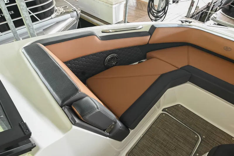 Slide: The Image of 2022 Cobalt R6 Surf boat interior with brown and black seating, docked at marina. - 39