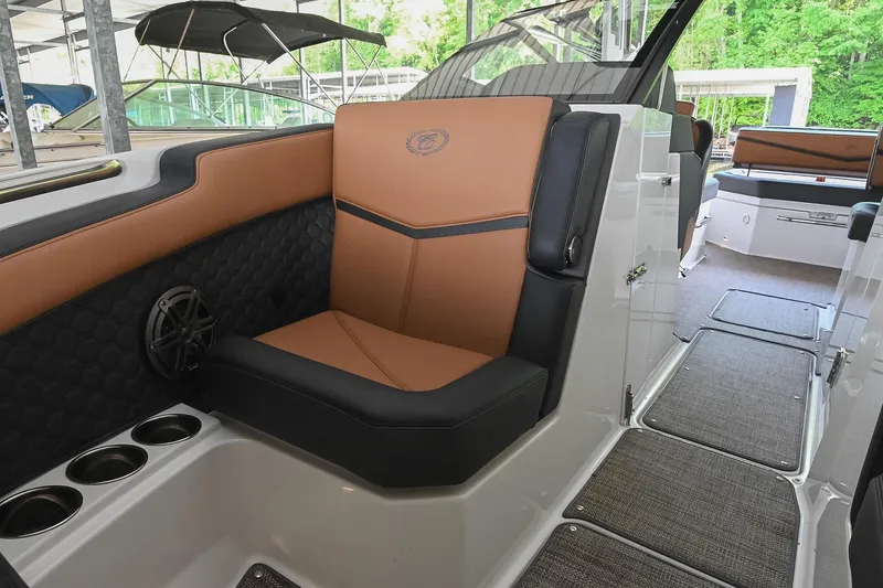 Slide: The Image of 2022 Cobalt R6 Surf boat interior with tan and black seating, cup holders, and speaker. - 42