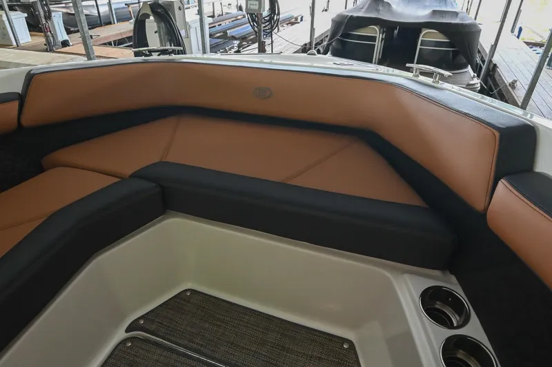 Slide: The Image of 2022 Cobalt R6 Surf boat interior with tan and black seating, cup holders visible. - 43