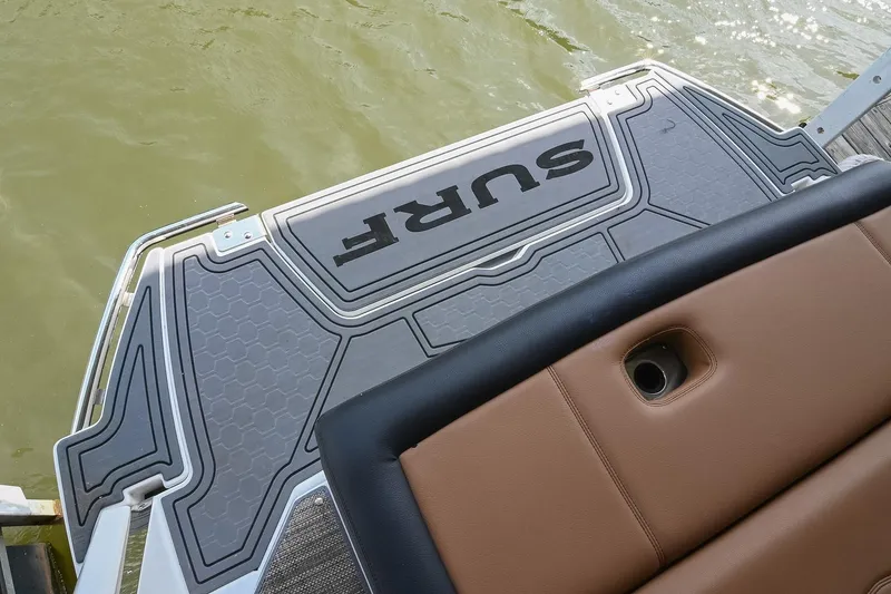 Slide: The Image of 2022 Cobalt R6 Surf boat swim platform with "SURF" logo, near water. - 9