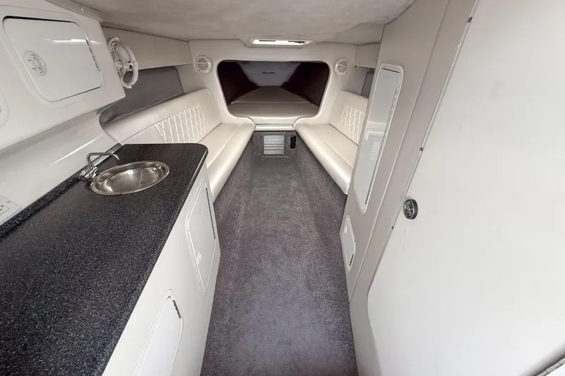 Slide: The Image of Interior of a 2002 Active Thunder 37 boat, featuring seating and a compact kitchenette. - 13