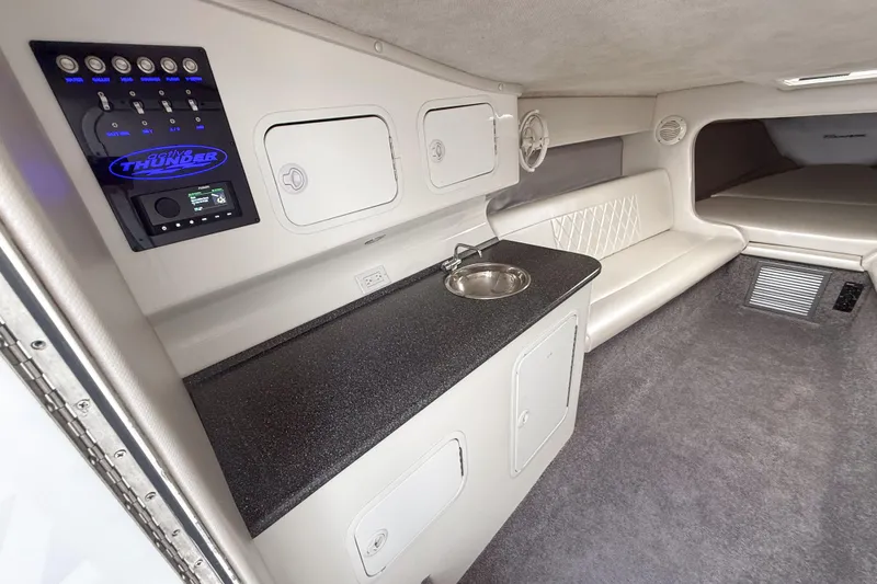 Slide: The Image of Interior of a 2002 Active Thunder 37 boat featuring a sleek cabin with seating and control panel. - 14