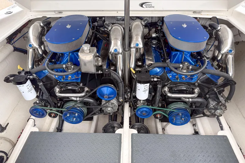 Slide: The Image of Twin engines in a 2002 Active Thunder 37 boat, featuring blue accents and chrome components. - 26
