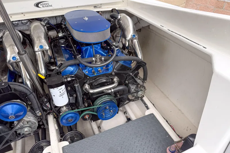 Slide: The Image of Engine compartment of a 2002 Active Thunder 37 boat, featuring a blue and chrome engine. - 29