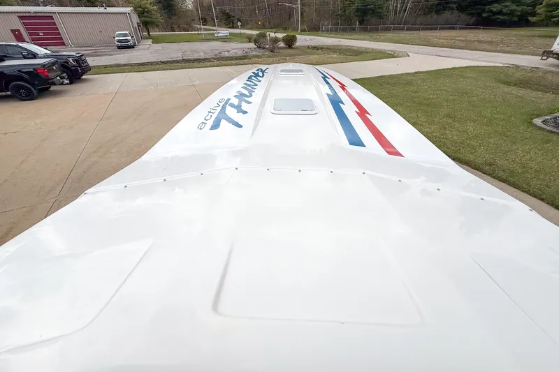Slide: The Image of 2002 Active Thunder 37 boat with sleek design and vibrant graphics on deck. - 31