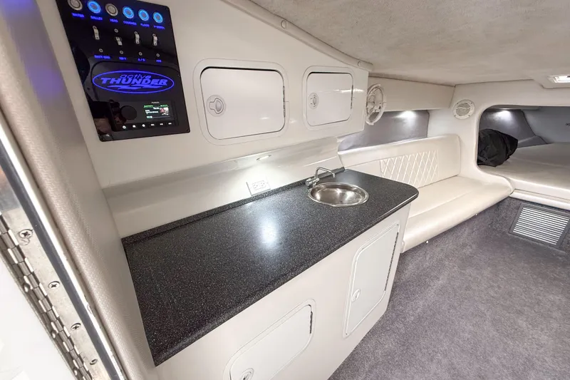 Slide: The Image of Interior of a 2002 Active Thunder 37 boat featuring a sleek kitchenette and seating area. - 37