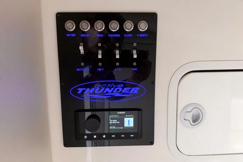Slide: The Image of Control panel of a 2002 Active Thunder 37 boat with labeled switches and audio system. - 41