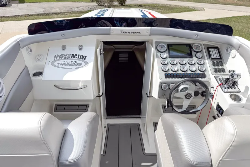 Slide: The Image of Cockpit of a 2002 Active Thunder 37 boat with steering wheel and control panel. - 45