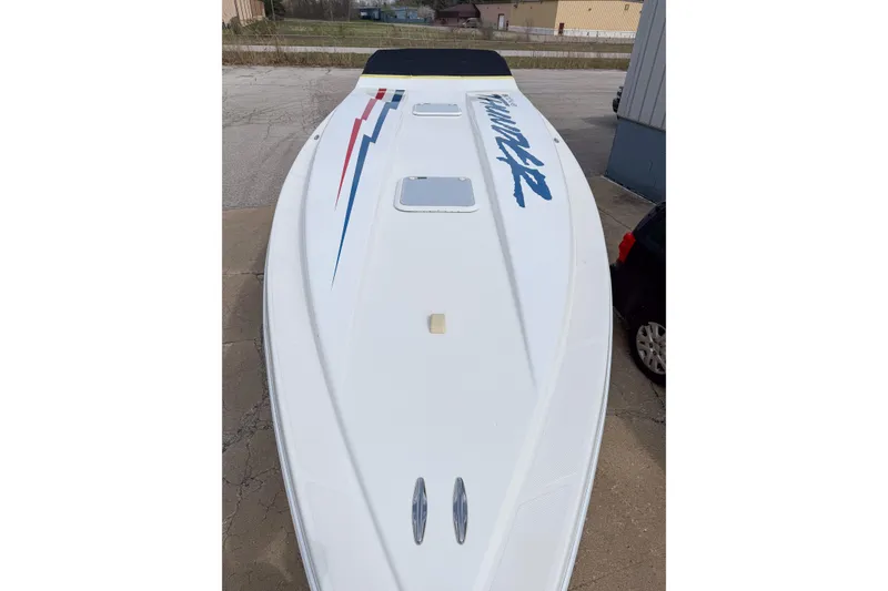 Slide: The Image of 2002 Active Thunder 37 boat with sleek white deck and bold graphics. - 5