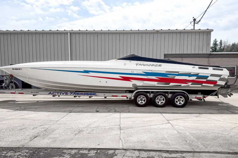 Slide: The Image of 2002 Active Thunder 37 speedboat on trailer, featuring sleek design and vibrant graphics. - 57