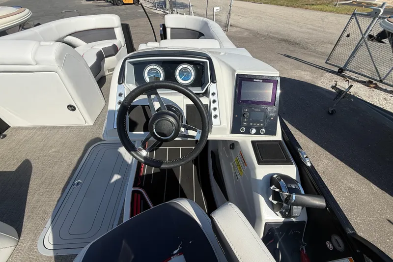 Slide: The Image of 2022 Barletta Corsa 23U boat dashboard with steering wheel and control panel. - 11