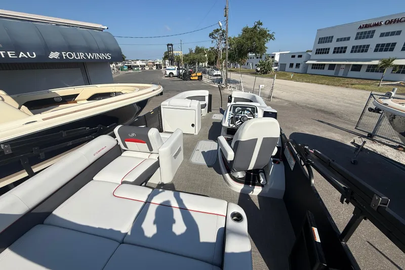 Slide: The Image of 2022 Barletta Corsa 23U pontoon boat with spacious seating and modern design at a marina. - 5
