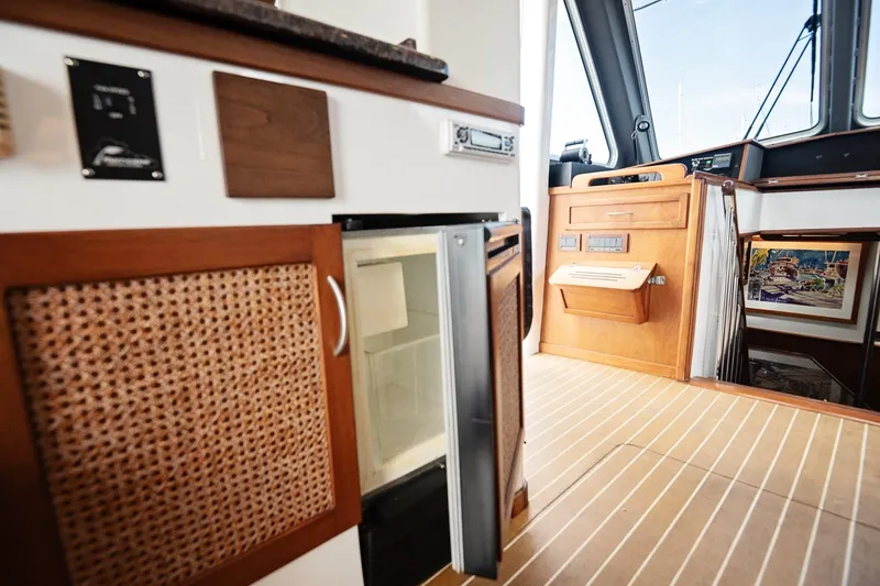 Slide: The Image of 2007 Pilot Cruiser Expedition interior with wood cabinetry and compact refrigerator. - 29