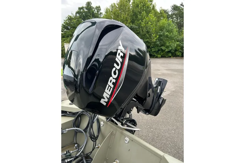 Slide: The Image of 2025 Tracker Grizzly 1648 SC boat with Mercury outboard motor in a parking area. - 4