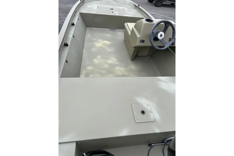Slide: The Image of 2025 Tracker Grizzly 1648 SC boat interior with steering console and spacious deck. - 5