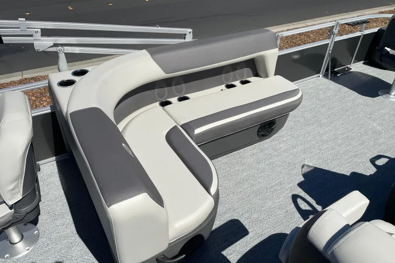 Slide: The Image of 2026 Sun Tracker Bass Buggy 18 DLX pontoon boat interior with cushioned seating and cup holders. - 21