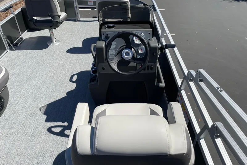 Slide: The Image of 2026 Sun Tracker Bass Buggy 18 DLX pontoon boat interior with steering console and seating. - 22