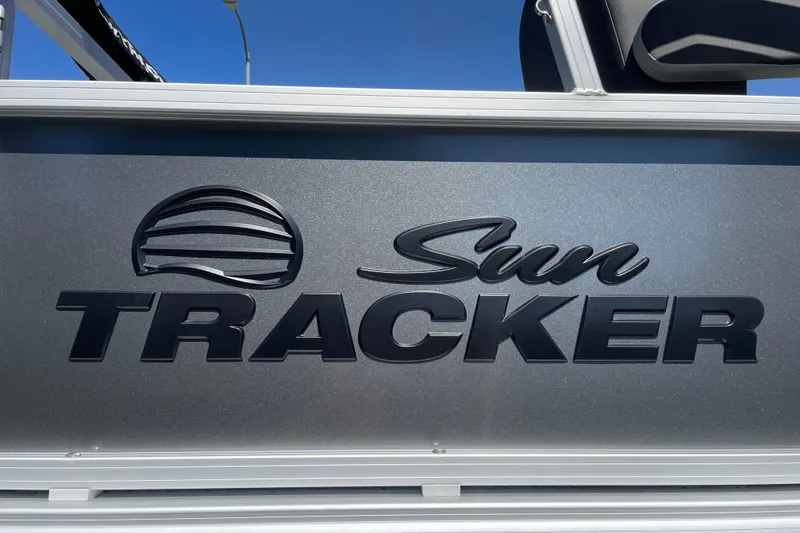 Slide: The Image of 2026 Sun Tracker Bass Buggy 18 DLX logo on metallic surface under clear blue sky. - 35