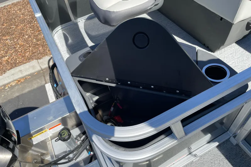 Slide: The Image of 2026 Sun Tracker Bass Buggy 18 DLX boat interior with open storage compartment and cup holder. - 28