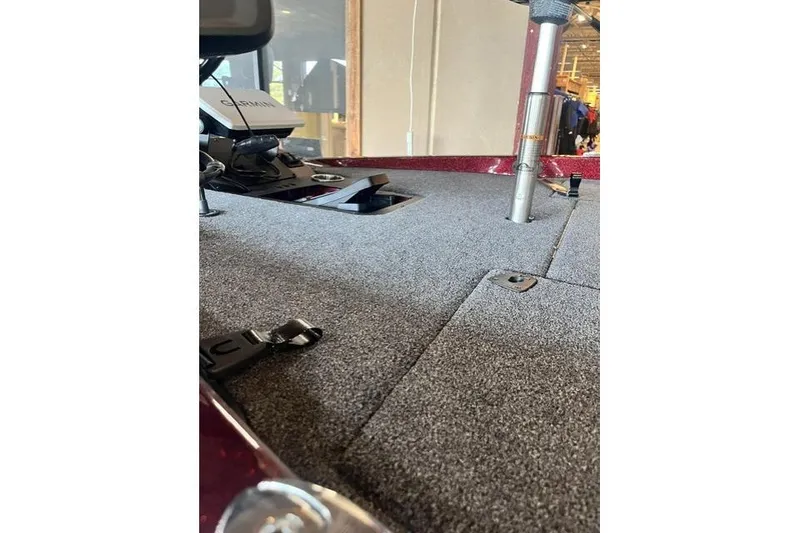 Slide: The Image of 2026 Ranger Z185 boat interior with carpeted deck and fishing equipment. - 2
