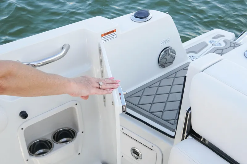 Slide: The Image of 2024 Finseeker 230 CC boat interior with hand on door, showcasing sleek design and functionality. - 12