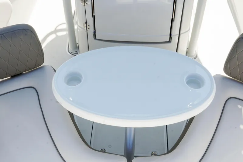Slide: The Image of 2024 Finseeker 230 CC boat interior with oval table and cushioned seating. - 24