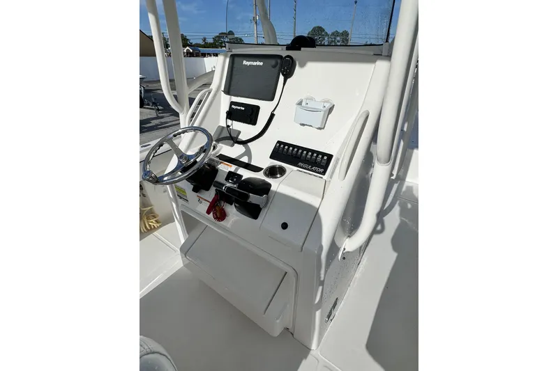 Slide: The Image of 2016 Regulator 25 boat console with steering wheel and Raymarine electronics. - 10