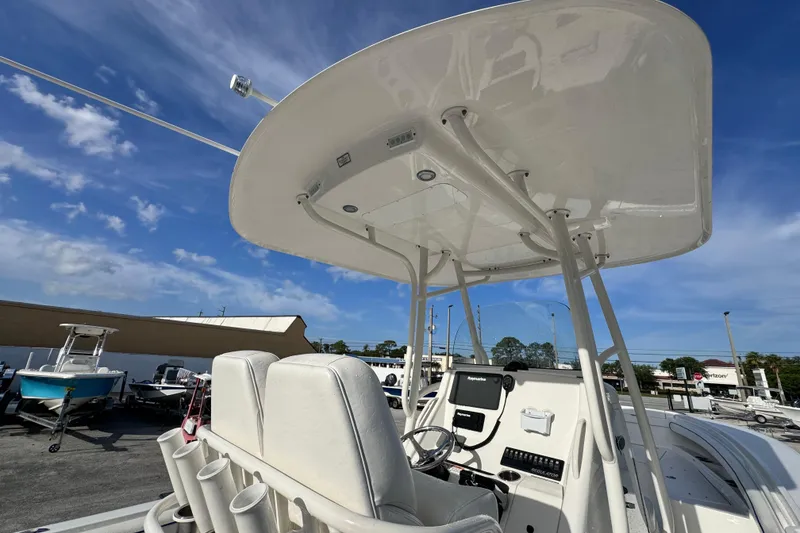Slide: The Image of 2016 Regulator 25 boat cockpit with T-top and navigation equipment under clear blue sky. - 12