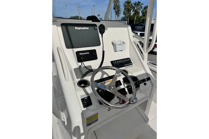 Slide: The Image of 2016 Regulator 25 boat console with Raymarine electronics and steering wheel. - 13