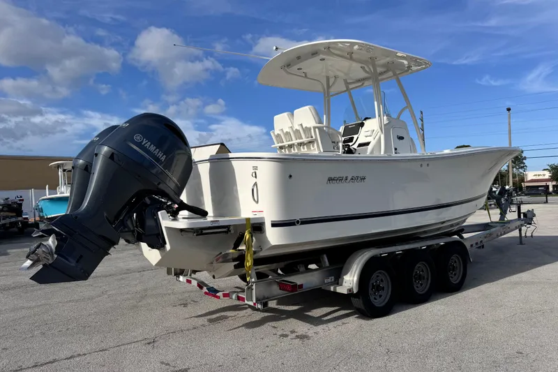 Slide: The Image of 2016 Regulator 25 boat on trailer with Yamaha outboard motor under blue sky. - 4