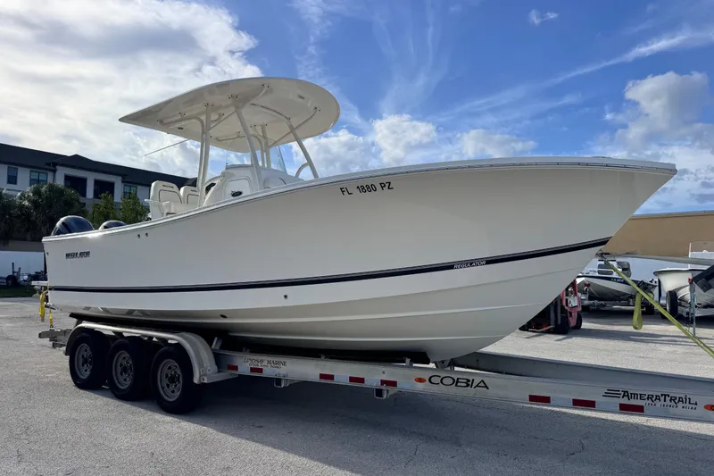 Slide: The Image of 2016 Regulator 25 boat on trailer under blue sky, side view. - 6