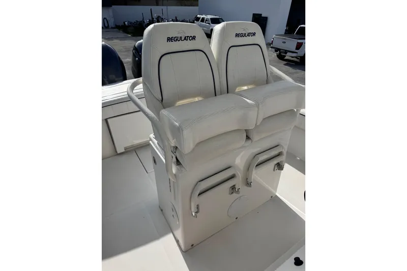 Slide: The Image of 2016 Regulator 25 boat seats, white leather, dual seating, outdoor setting. - 9