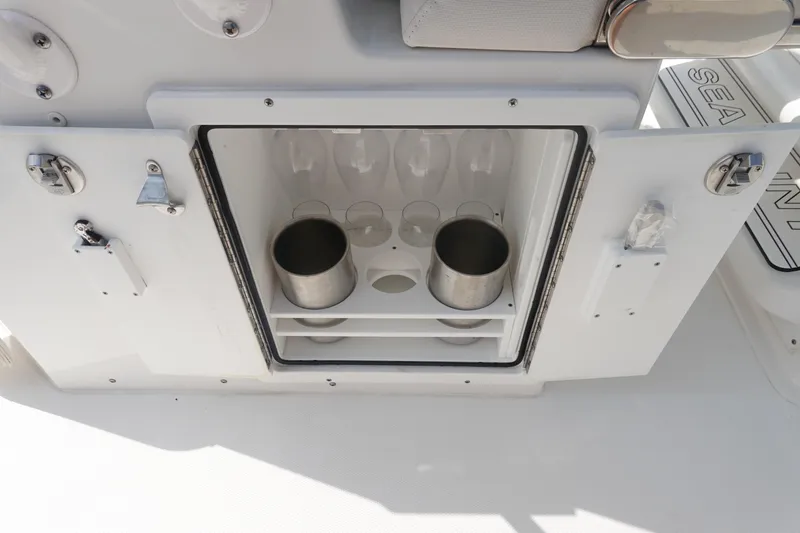 Slide: The Image of 2023 Sea Hunt Escape 28 boat storage compartment with cup holders and secure latches. - 17