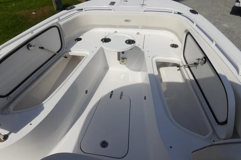 Slide: The Image of 2023 Sea Hunt Escape 28 boat interior with open storage compartments and seating area. - 28
