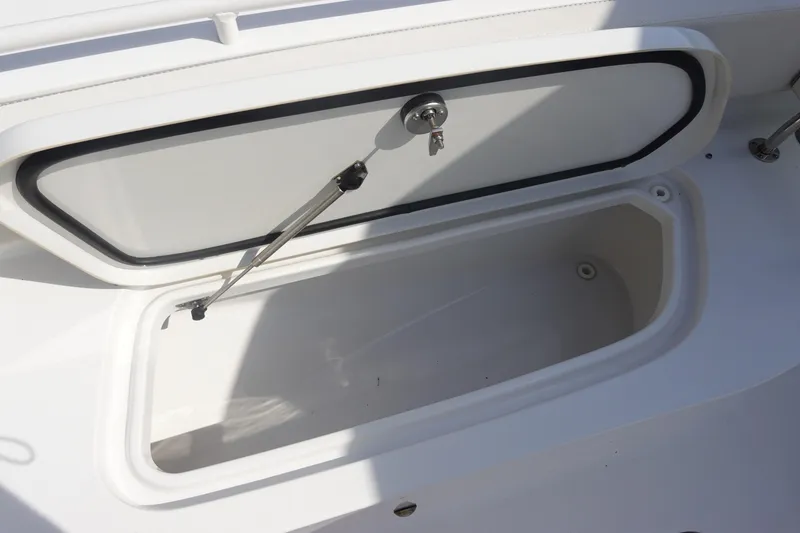 Slide: The Image of Open storage compartment on 2023 Sea Hunt Escape 28 boat, featuring secure lock and hydraulic support. - 29
