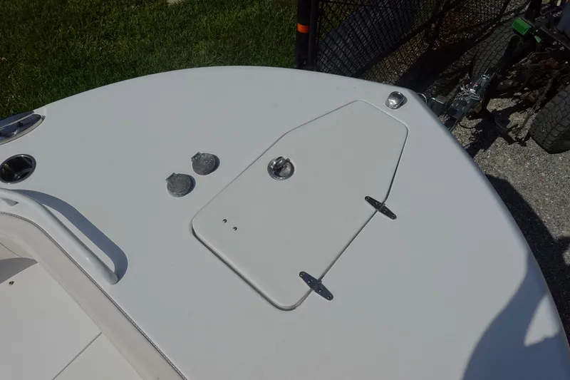 Slide: The Image of 2023 Sea Hunt Escape 28 boat deck with hatch and fittings, parked on gravel. - 32