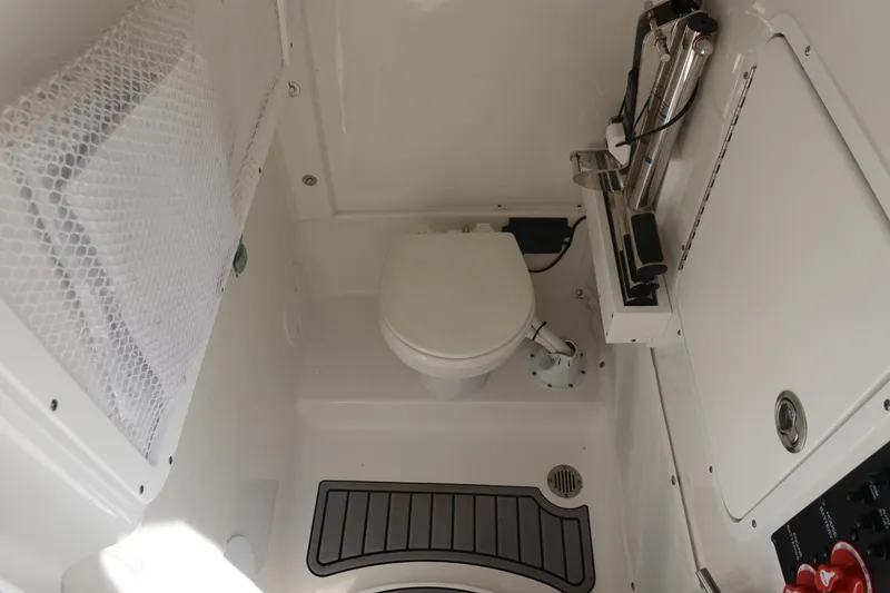 Slide: The Image of 2023 Sea Hunt Escape 28 boat interior with compact marine toilet and storage. - 34